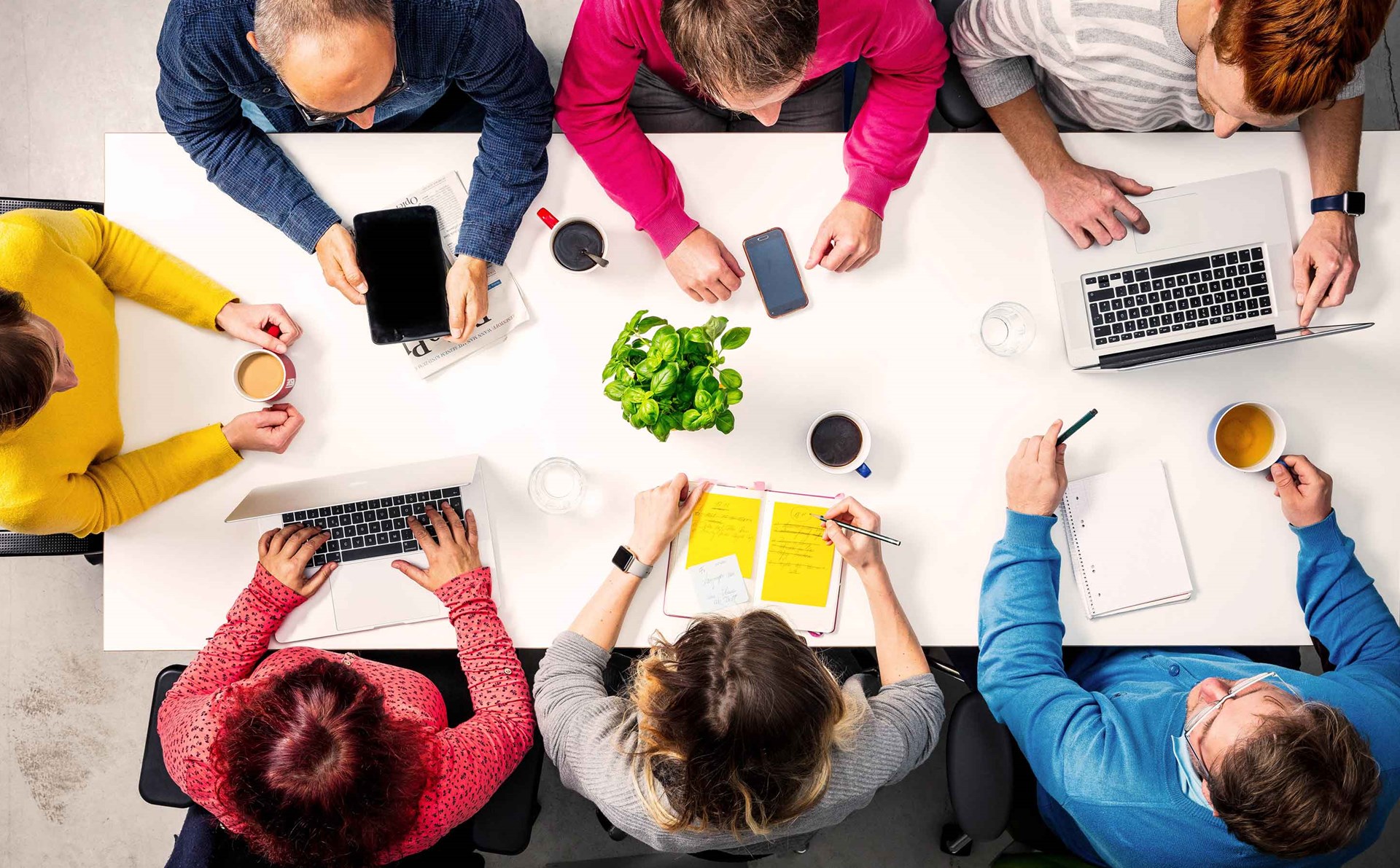 Kundenbeirat enviaM Treffen eines Kundenbeirats am Tisch mit Laptop und Tasse und Stift.