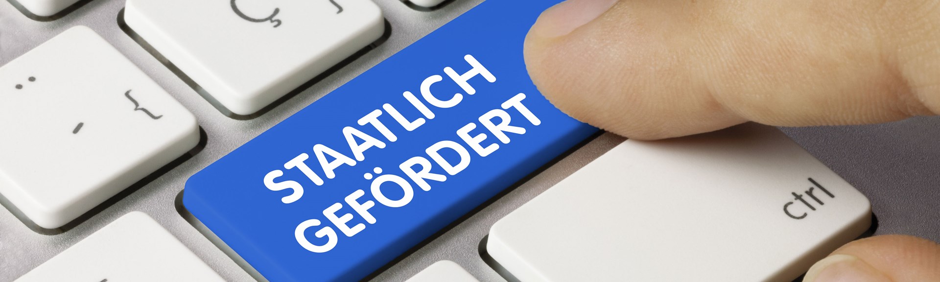 Fördermitteldatenbank Eine Computertastatur mit einer blauen Taste unter der Enter-Taste. Auf dieser steht: Staatlich Gefördert.