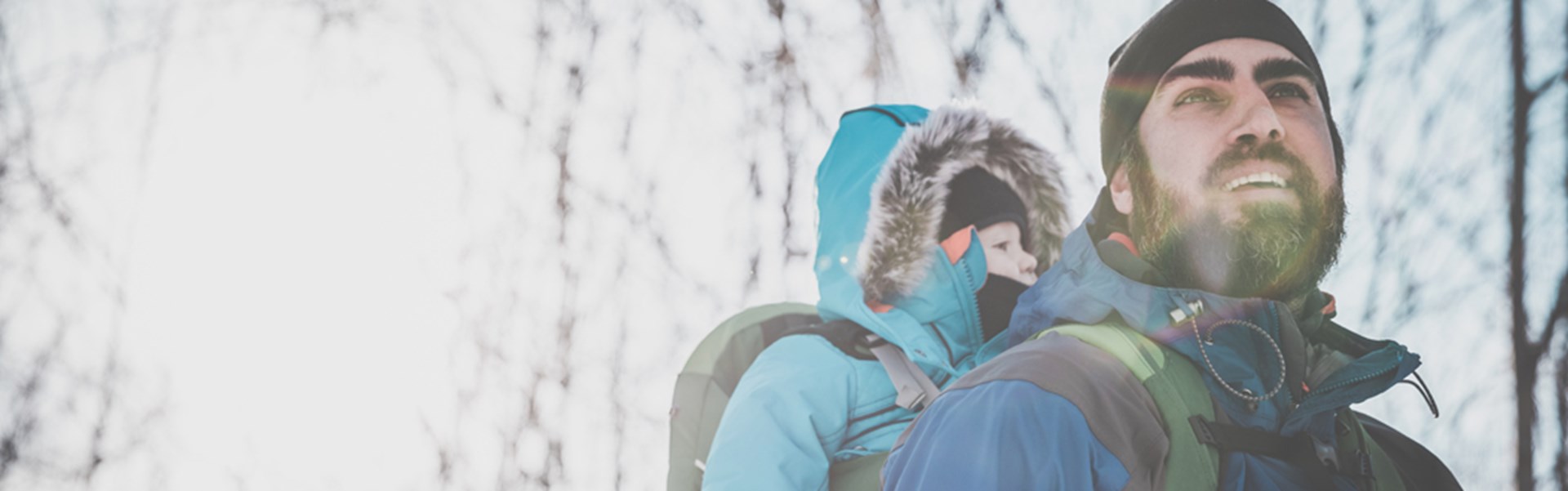 Wandern Ein Mann wandert mit seinem Kind auf dem Rücken